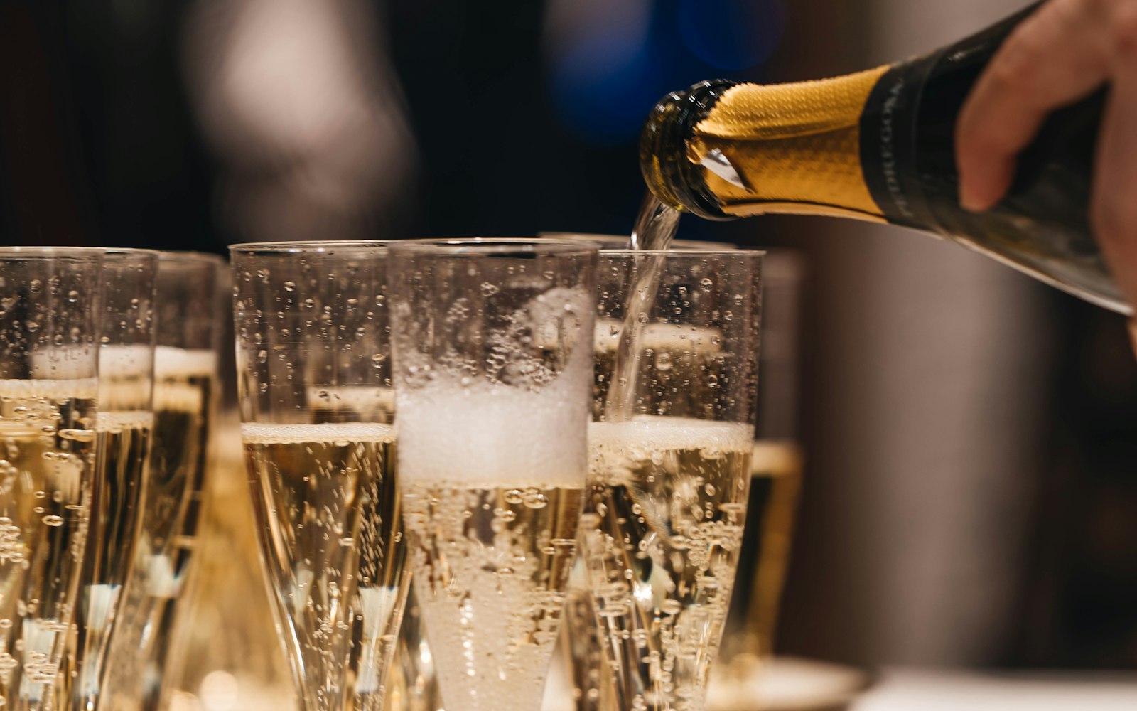 Wedding guests raising glasses of champagne in a toast at the reception