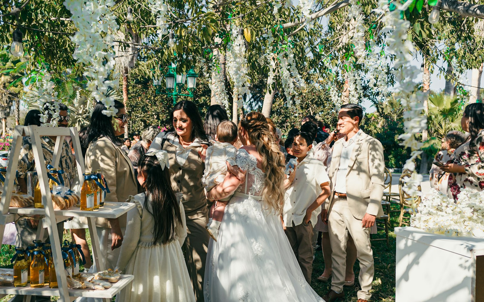 A bride and groom surrounded by guests at an outdoor ceremony